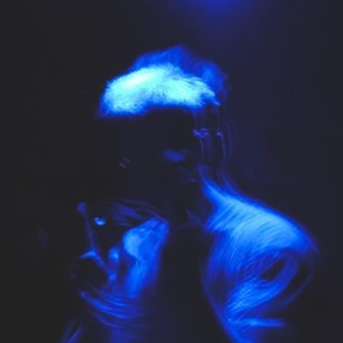 Smear in blue light, black background, multiple blurred exposures