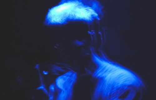 Smear in blue light, black background, multiple blurred exposures