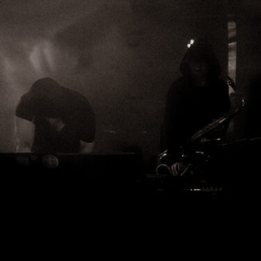 dark shadowy photo taken of A Vengeance performing in Scotland.